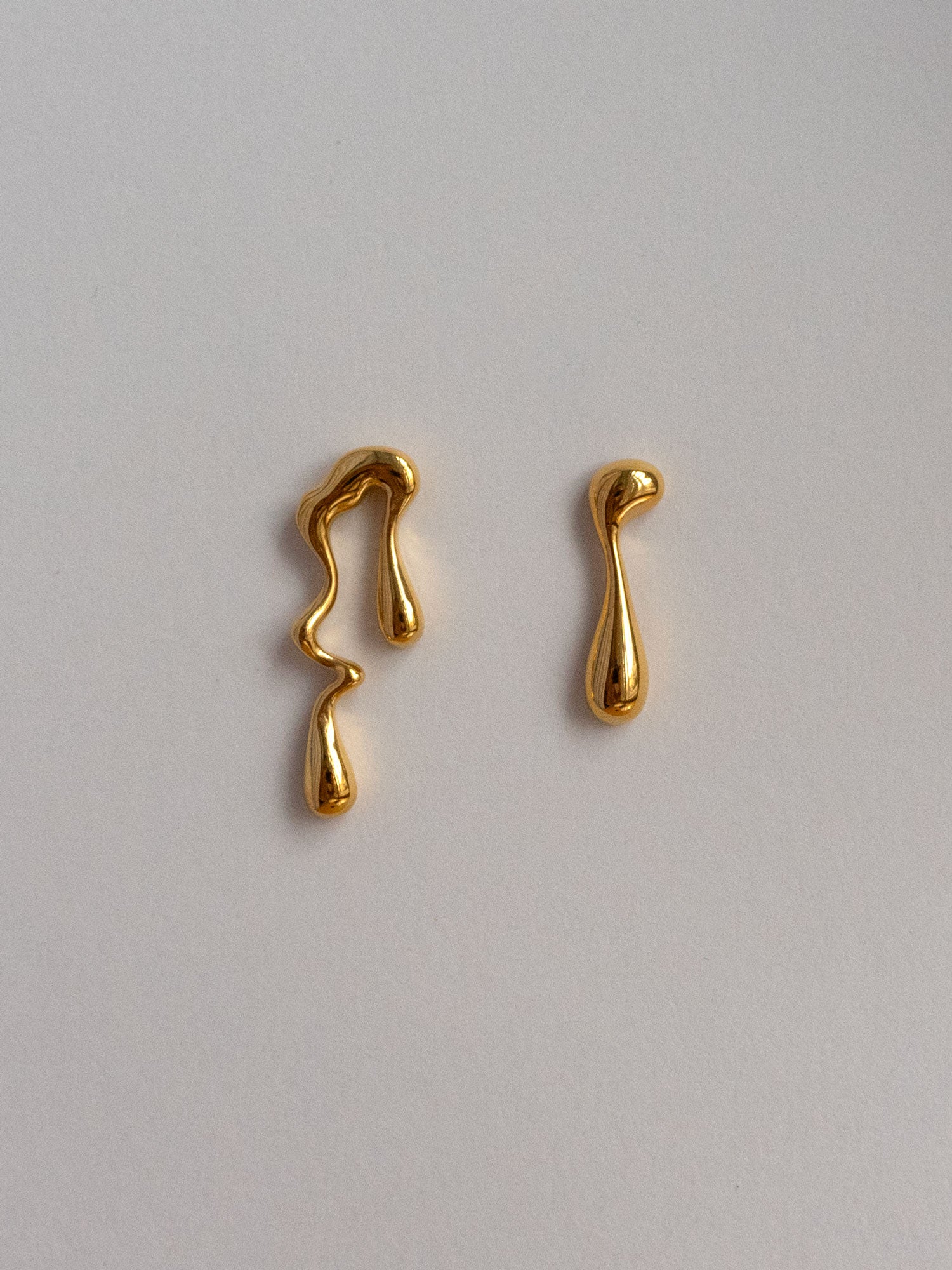 Boucles d’oreilles asymétriques dégoulinantes de peinture dorée